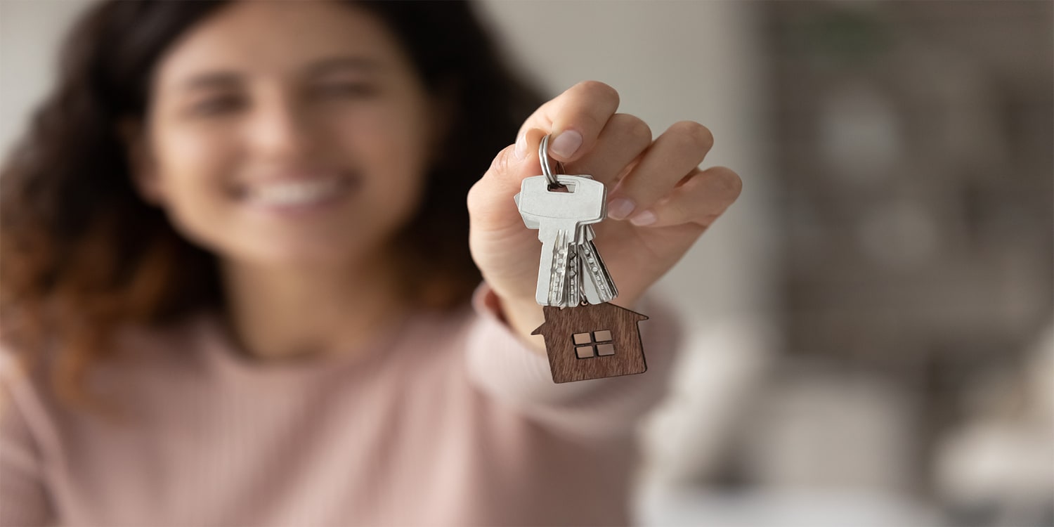 woman holding out house keys - motivated home sellers concept